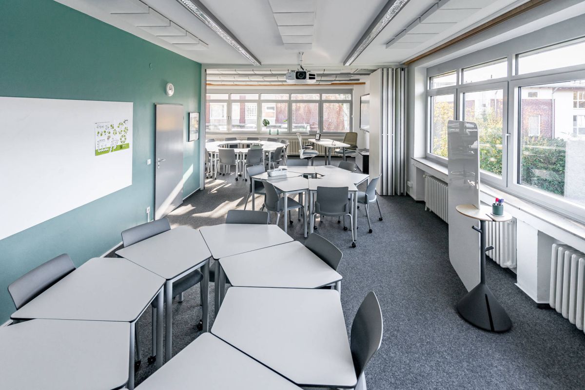 Ein Schulungsraum mit mobilen Einzeltischen in Sitzhöhe die bei Bedarf zusammengeschoben und gemeinsam genutzt werden